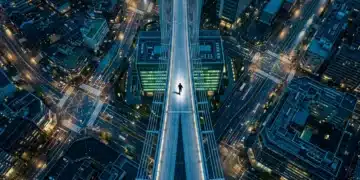 Aerial view of a city at twilight with illuminated streets forming geometric patterns, a lone person walking on a bridge, symbolizing business intelligence and strategic growth.